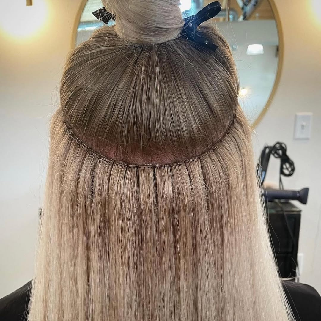 Close-up of a beaded row hair extension installation on blonde hair at Ella Rose Hair Boutique in Albuquerque, NM.