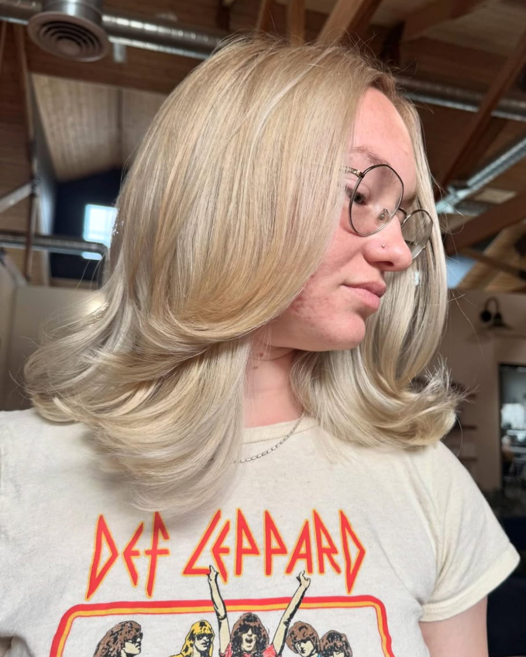 Woman with short hair featuring a vibrant, beach blonde color and layers