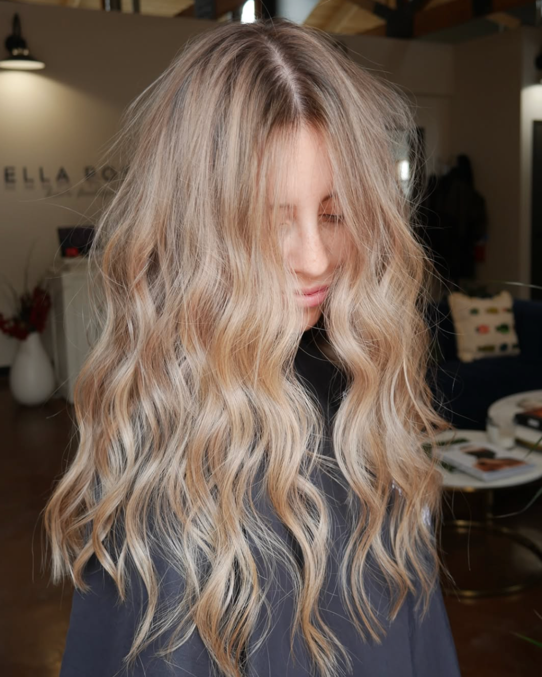 Woman with long blended blonde hair featuring soft beige and light blonde tones styled in loose waves.
