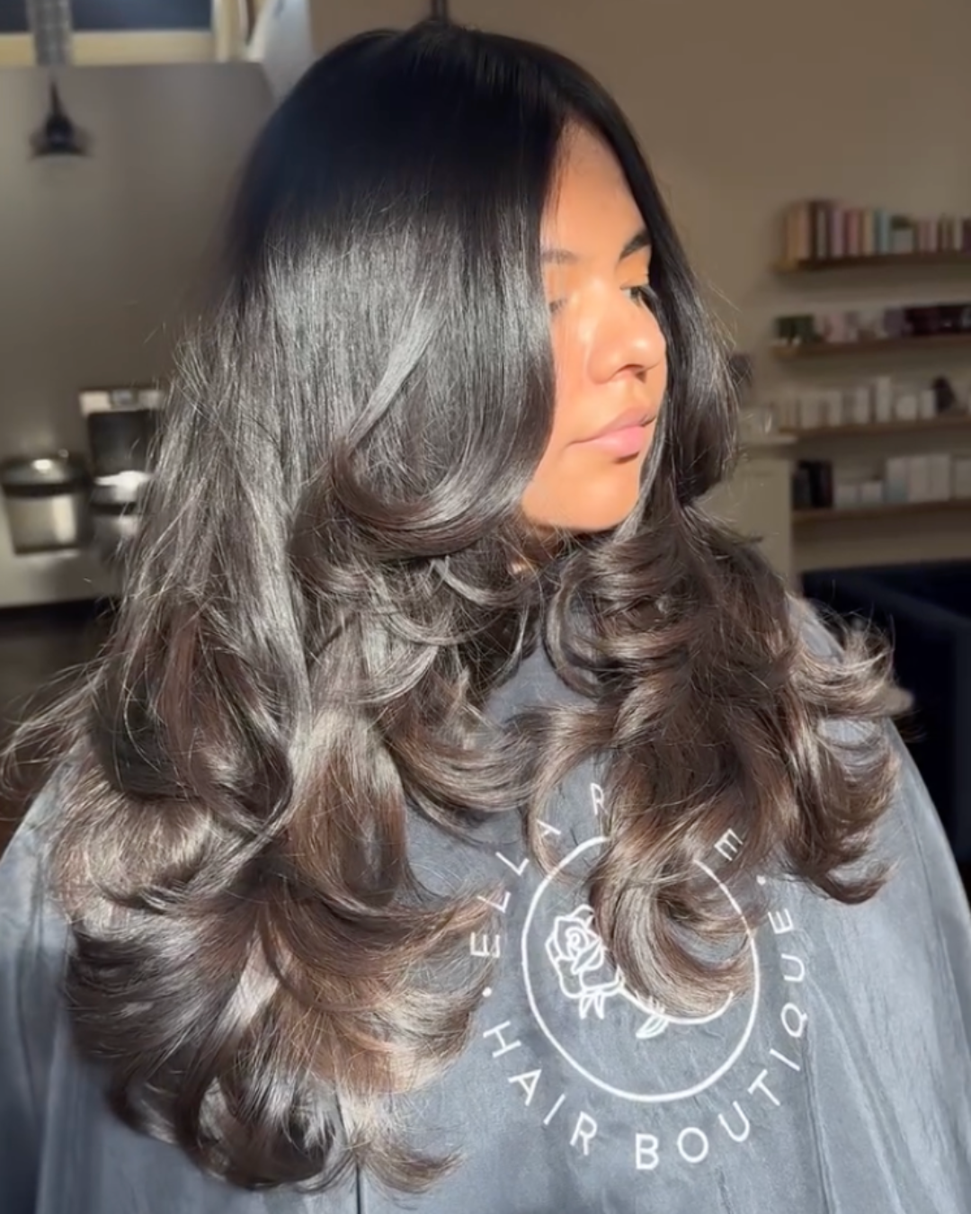 Woman with deep midnight brown hair and strong flippy layers