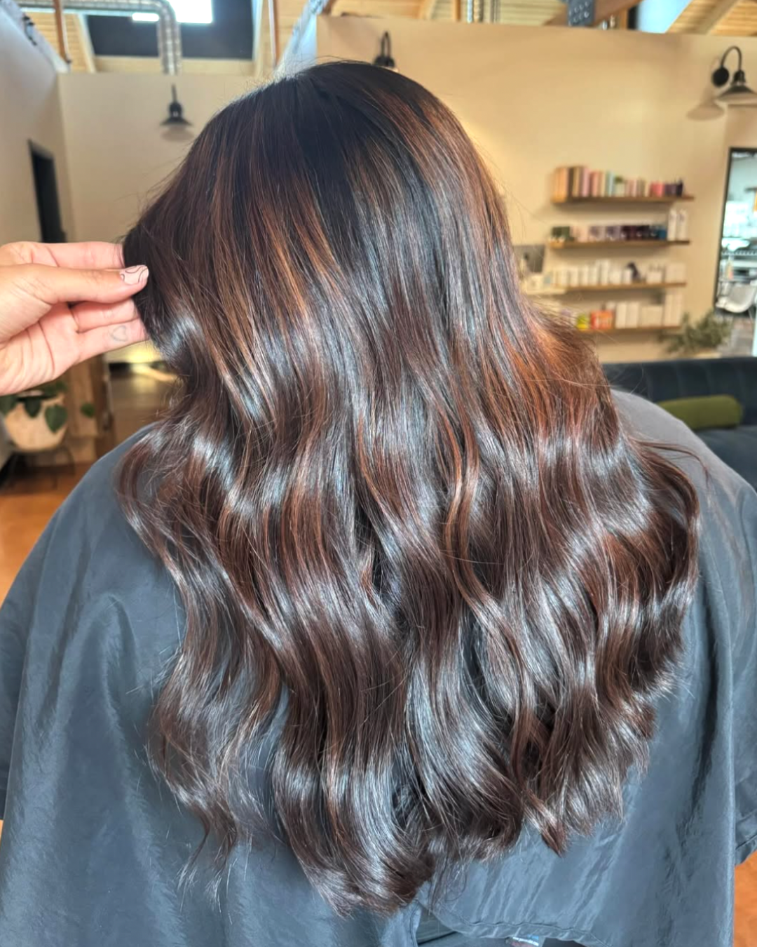 Back view of a woman with chocolate brown hair and caramel highlights