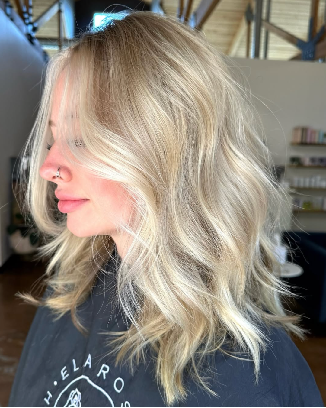 Side view of a woman with shoulder length hair in a cool, blended ash blonde color
