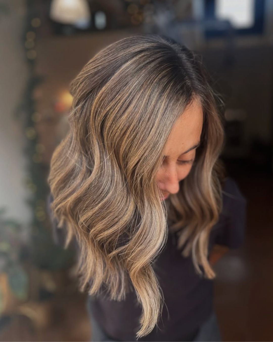 Woman with shoulder-length cool bronde hair featuring blended brunette and cool blonde tones styled in soft waves.