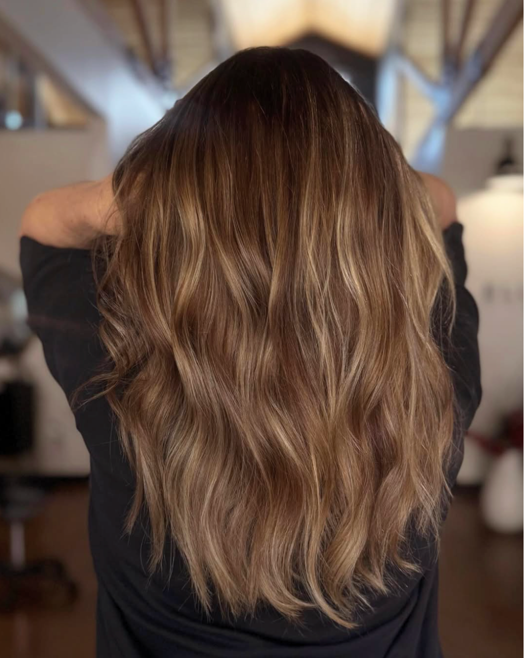 Woman with darker bronde hair with highlights throughout for a brightness