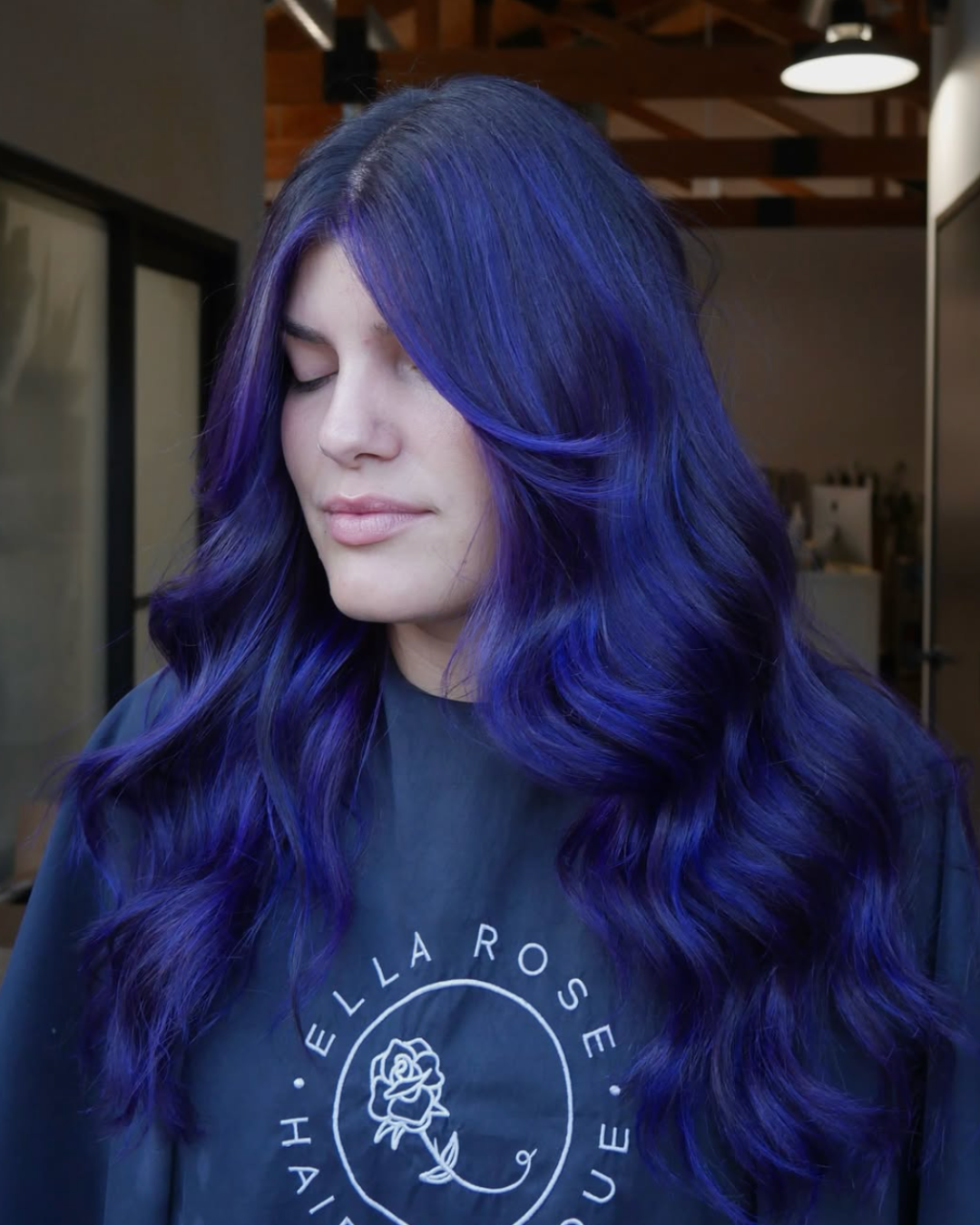 Woman with long wavy hair and and face framing featuring a full bright, electric cobalt color
