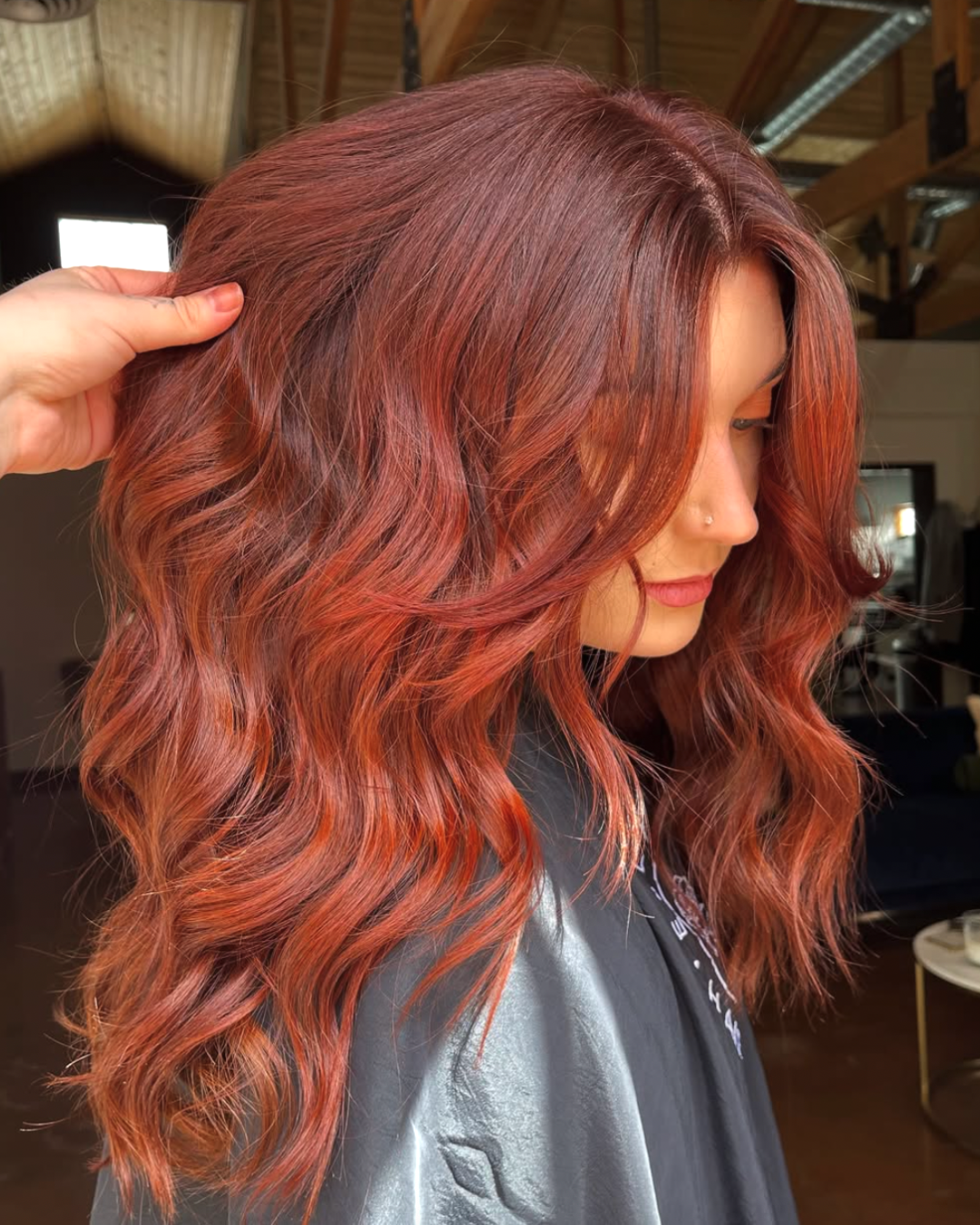 Woman with long layered wavy hair in a fiery copper color