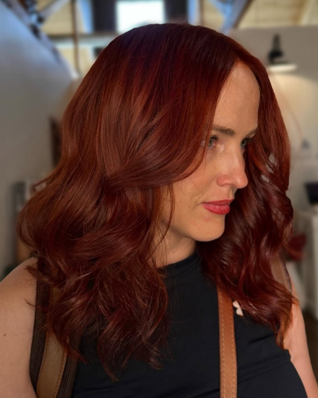 Woman with shoulder length hair in a deep, full foxy red color