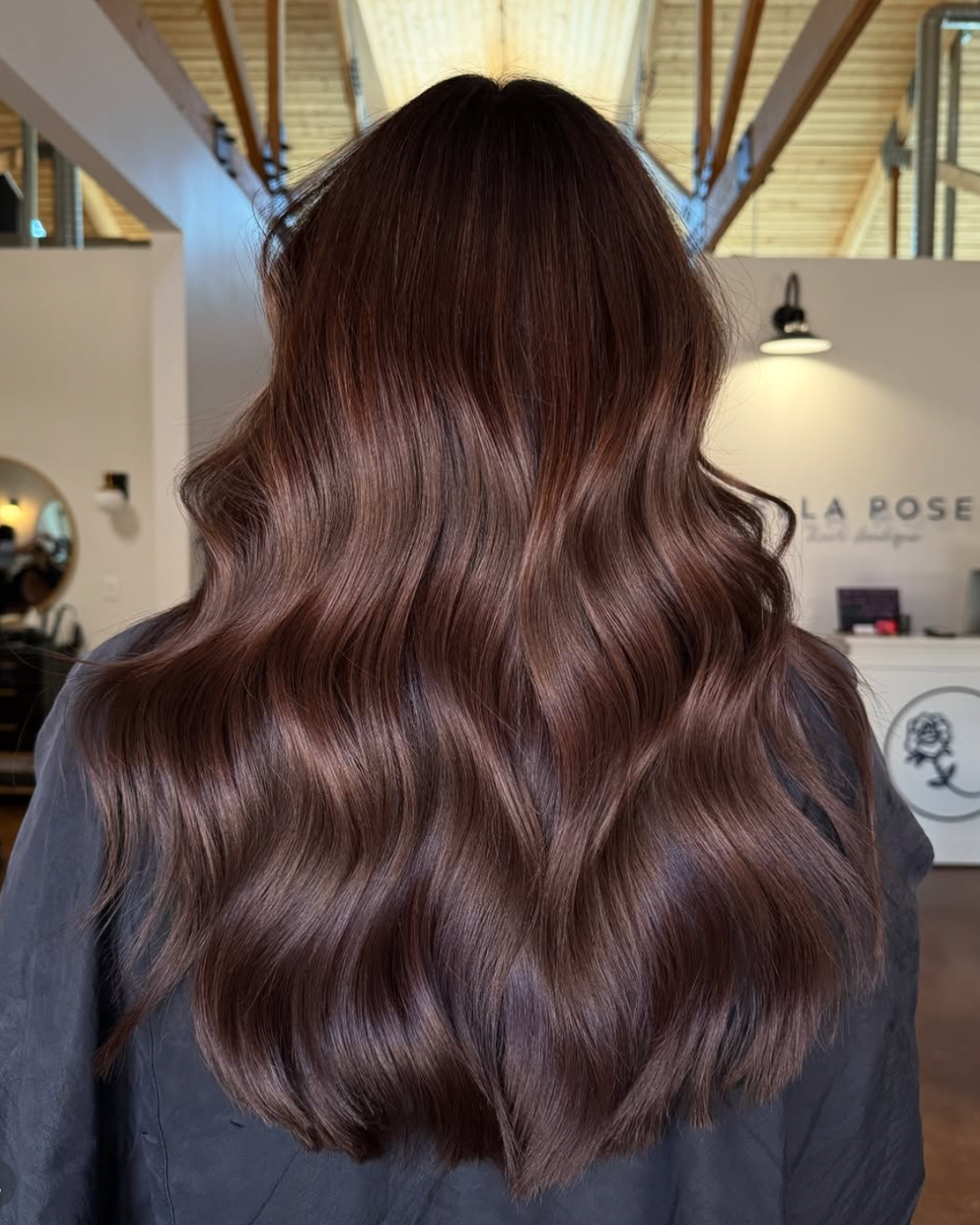Back view of a woman with long hair featuring a full, rich hazelnut color
