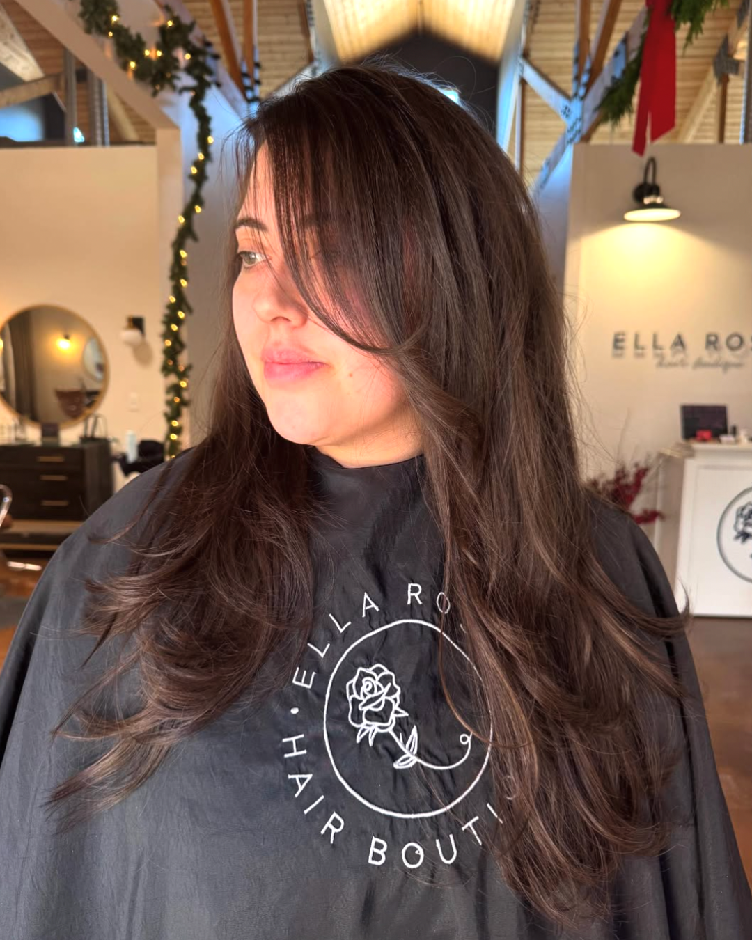 Woman with long layered brunette hair and face framing