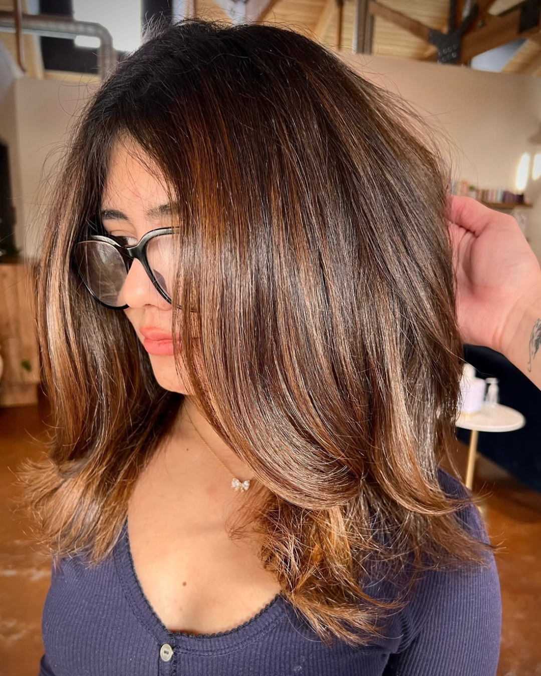 Woman with Medium length, layered, lived in brunette hair and highlights throughout