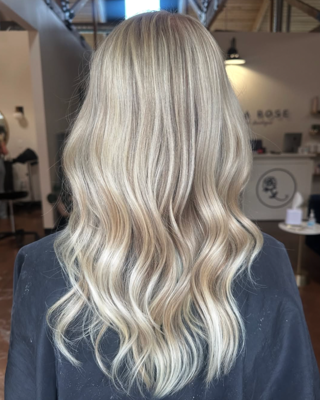 Back view of a woman with bright, pearl blonde hair featuring lively blonde highlights