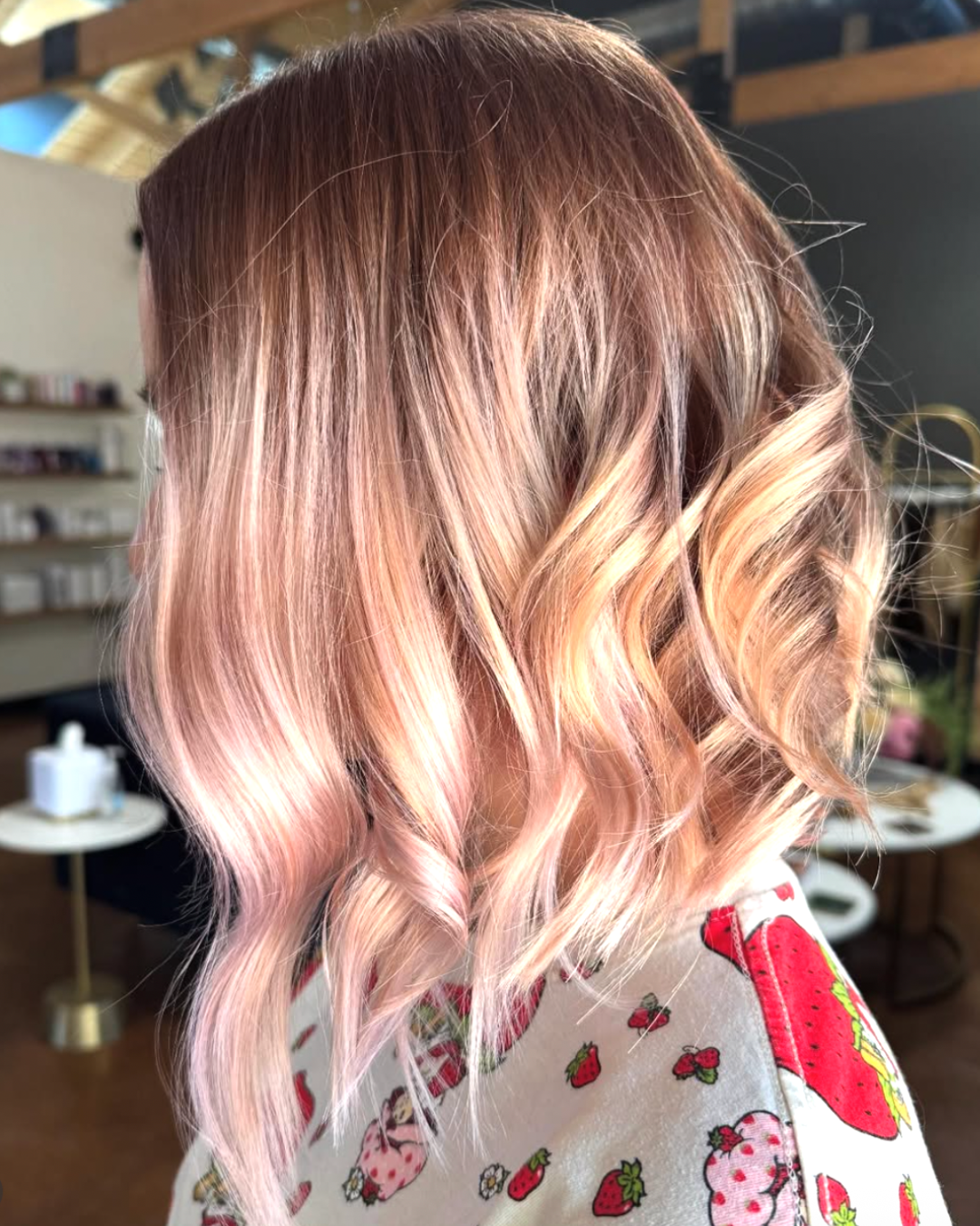 Side view of a woman with dimensional, strawberry blonde wavy hair