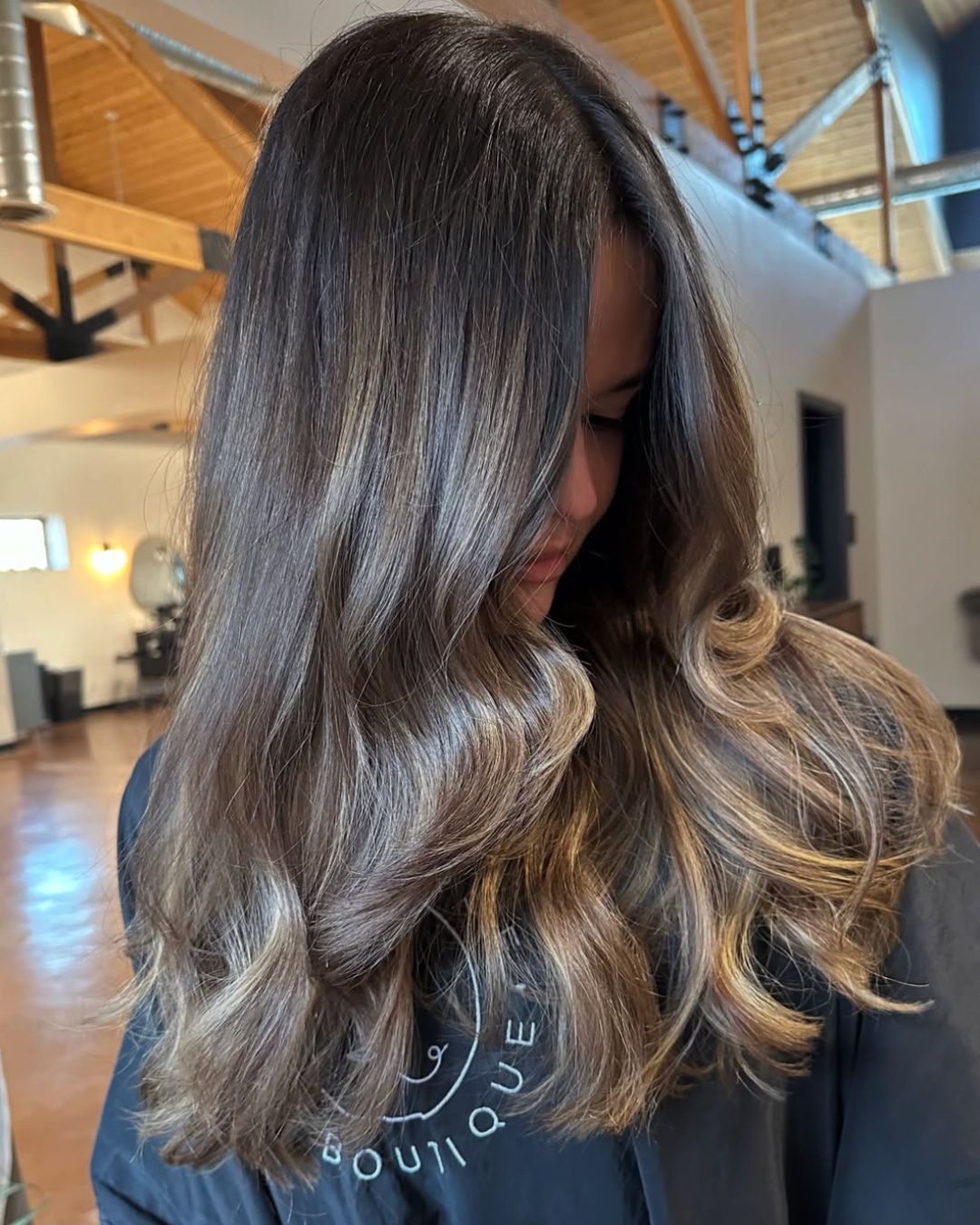 Side view of a woman with dark brown roots and blond ends after a toner refresh