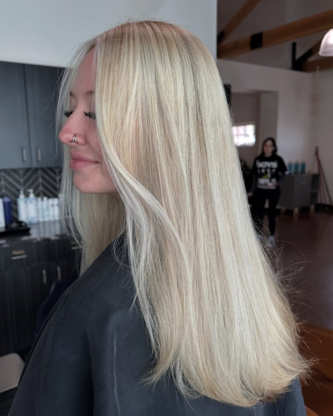 Side view of a woman with vibrant bondi beach blonde hair and long layers