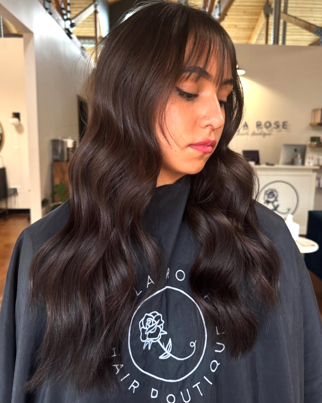 Woman with long, dark brunette hair and wispy bangs